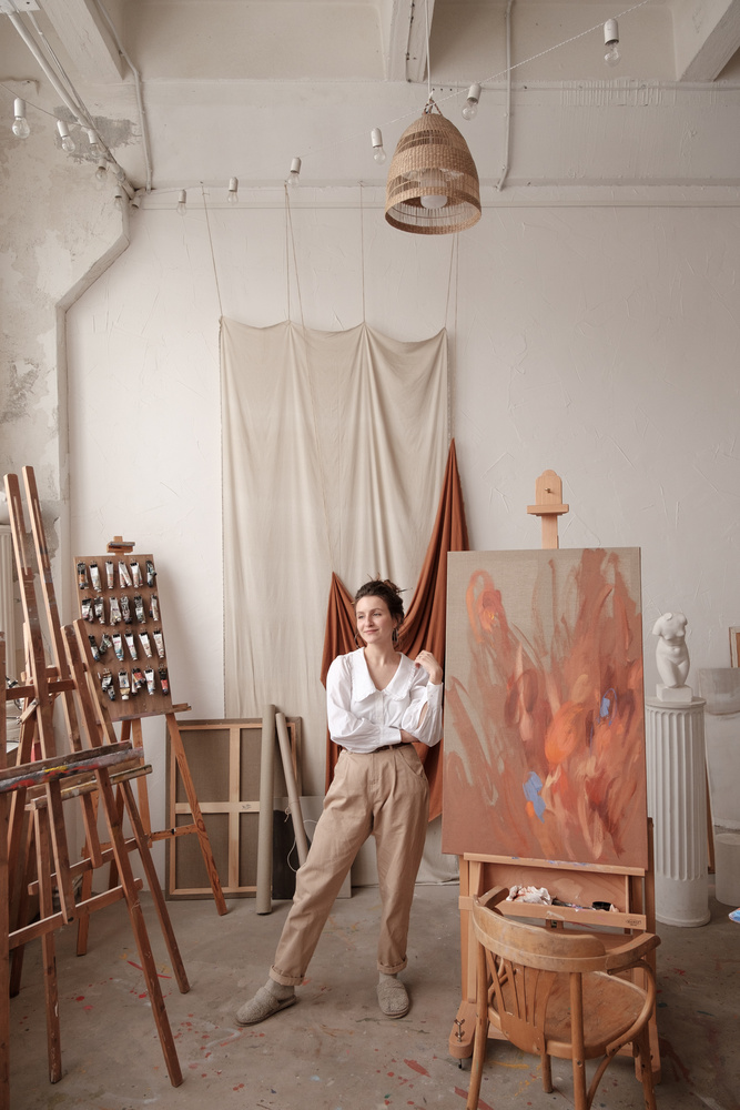 Female Artist Standing  with Painting in Studio